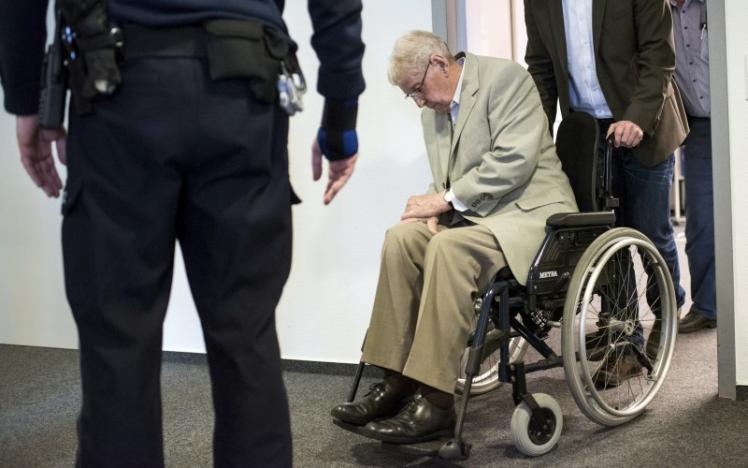 Defendant Reinhold Hanning, a 94-year-old former guard at Auschwitz death camp, is pushed in a wheelchair after a break in his trial in Detmold, Germany, in this file picture taken February 18, 2016. REUTERS/Bernd Thissen/Pool/Files